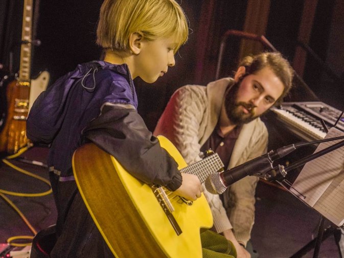 Guitar Students Taking Guitar Lessons From A Local Guitar Teacher Kid Guitar Student At Rock The Stages Music School in Aurora/Centennial Performing Live On Stage